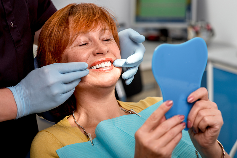woman choosing dentures or dental implants